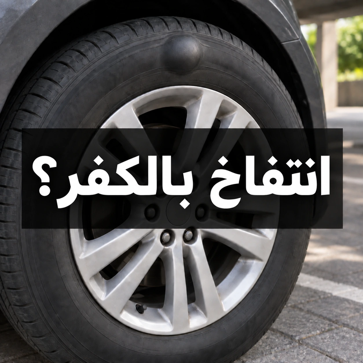 انتفاخ موضعي في الجدار الجانبي لإطار سيارة متوقفة مع عبارة انتفاخ بالكفر؟ في وسط الصورة